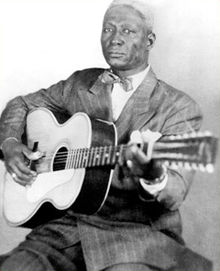 Lead Belly with guitar by Alan Lomax